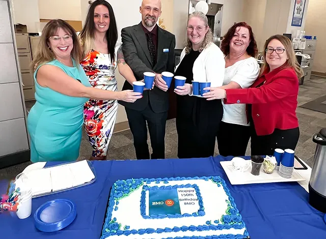 SF-BMO-group Smiths Falls BMO staff celebrate with cake.