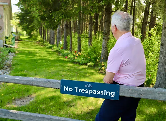Ray Hook standing in front of the Perthmore corridor fence/no trespassing sign.