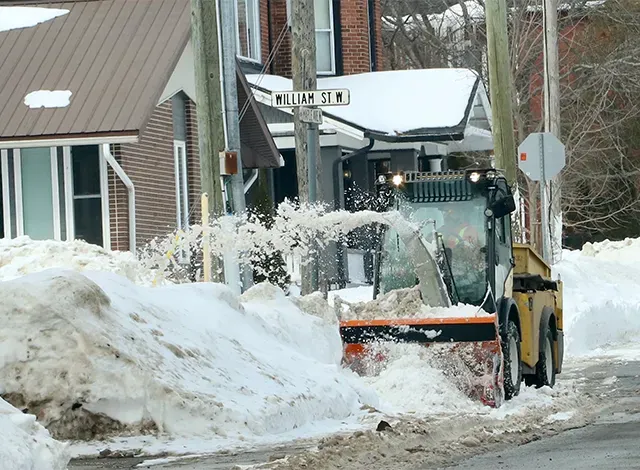 SF Street snow cleaner Snow plow throwing snow on a snowbank off the road.