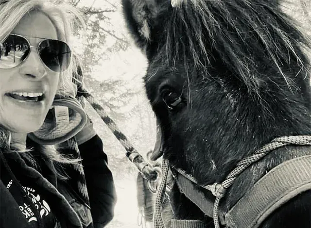 Close up of willow creek stables co owner with one of their horses.