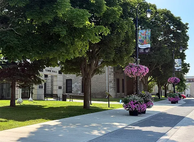 Smiths Falls Town Hall 2025 Green trees and purple flower planters sitting around and hanging on light posts just outside of Smiths Falls town hall where council keeps CIP fall intake deadline at Sept. 1 with $13,600 in available funding.