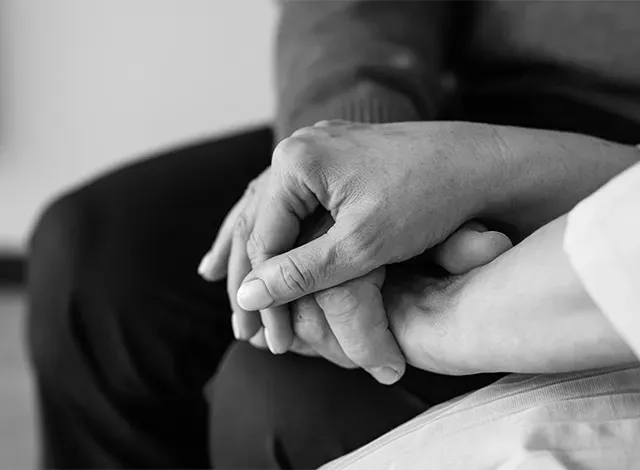 Black and white close up of hand holding. CHSLC has made its grief and bereavement program permanent, responding to community demand and Ministry of Health approval.