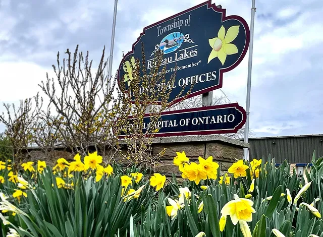 rl-daf Rideau Lake municipal office sign with yellow daffodils below, just outside where council meets.